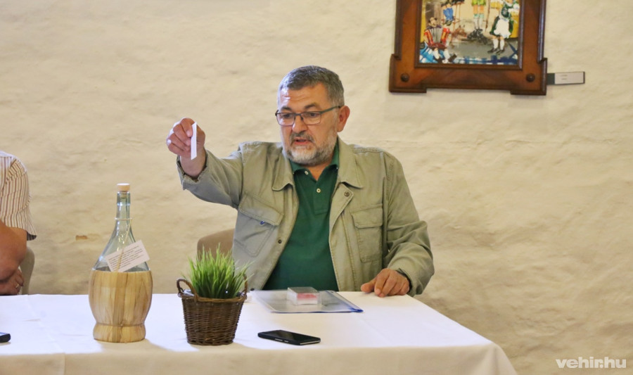 Debreczeny Zoltán mutatja, miként kell a papírt az üvegbe dobni