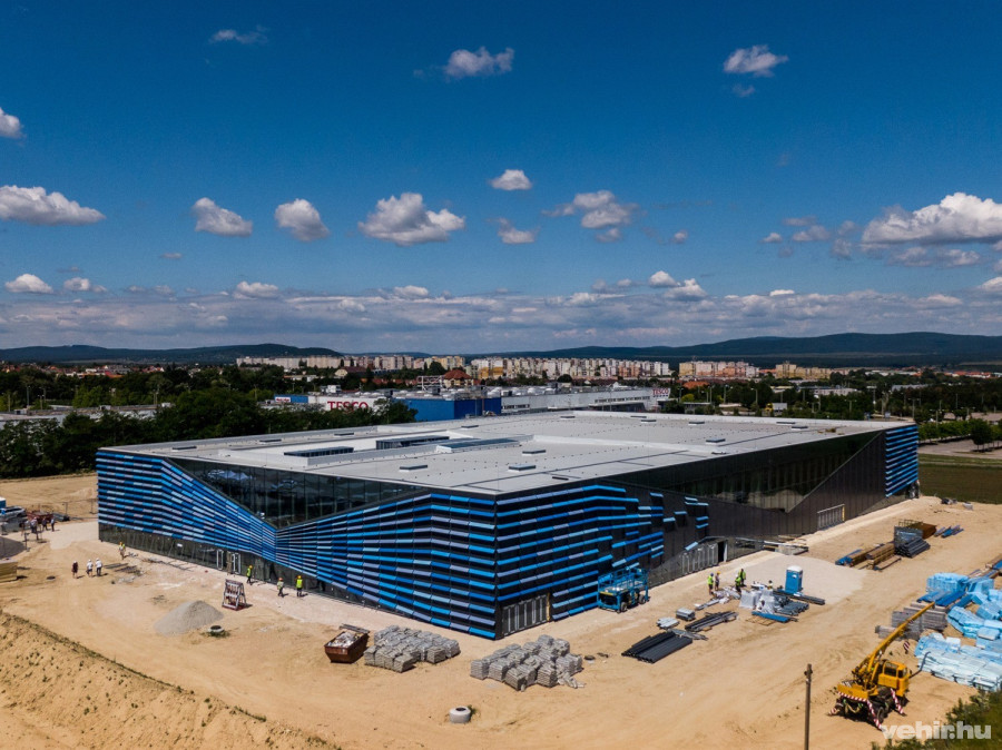 A homlokzat acél falvázbordákra szerelt szendvicspanel és függönyfal szerkezetű. Az árnyékoló lamellák a víz hullámzását szimbolizálják