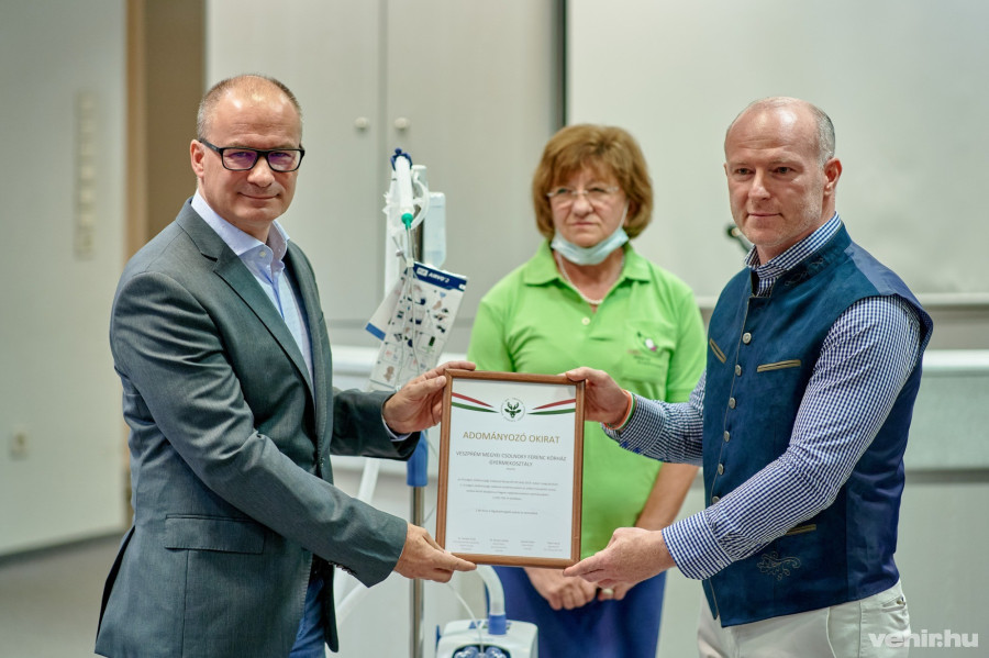 Lippai Norbert kórházigazgató és Fejes László ügyvezető igazgató az adományozó okirattal. A háttérben Szabó Éva, a megyei kórház gyermekosztályának vezető főorvosa.