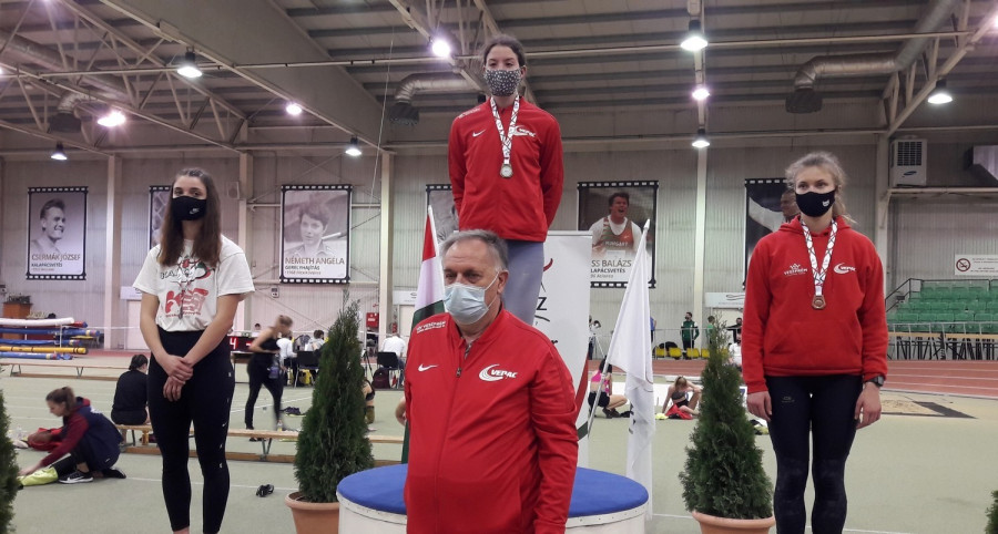 Fekete Júlia a dobogó tetején, a balján Rédling Renáta, előttük Kungl József edző - Fotó: VEDAC