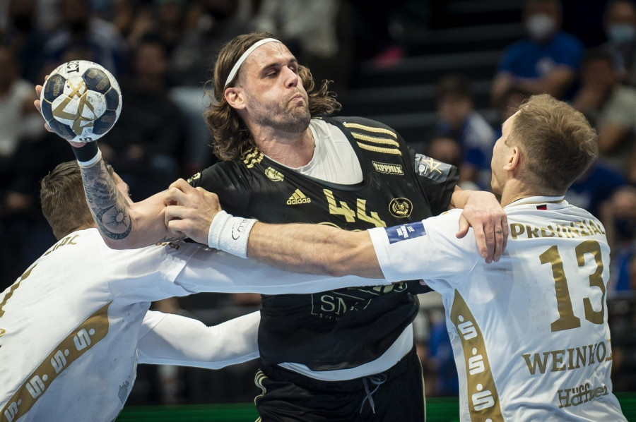 A szegedi Bombac Dean, valamint Hendrik Pekeler (b) és Steffen Weinhold, a német csapat játékosai a férfi kézilabda Bajnokok Ligája csoportkörének 10. fordulójában játszott Pick Szeged - THW Kiel mérkőzésen a szegedi Pick Arénában 2021. december 9-én. MTI/Ujvári Sándor