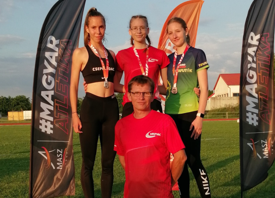 Szemán Kata a dobogó tetején, előtte edzője, Szemán János - Fotó: VEDAC
