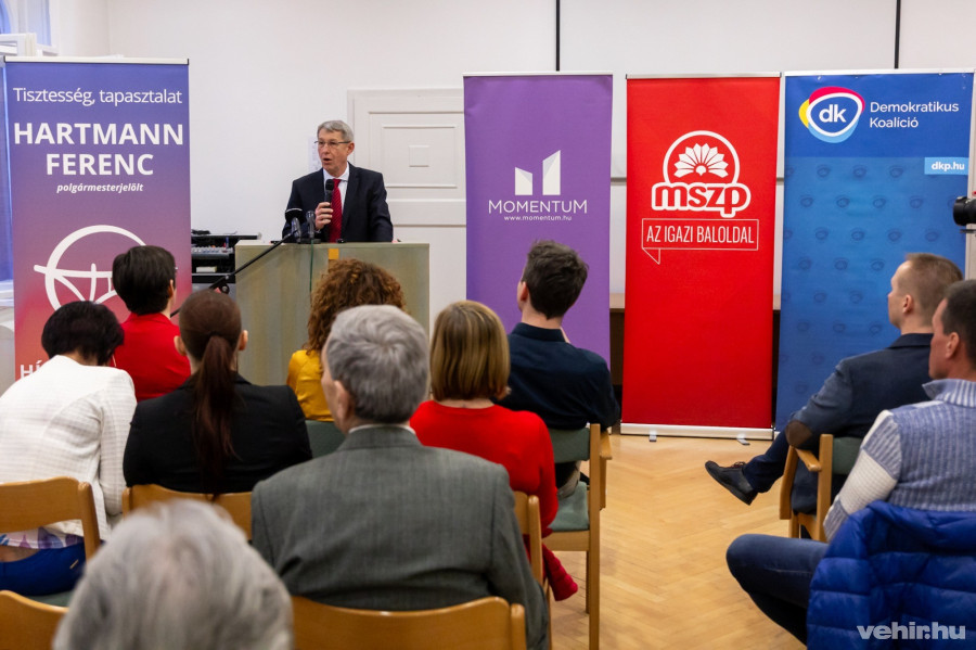 Hartmann Ferenc a bejelentésen, mögötte a pártok és az egyesület logói